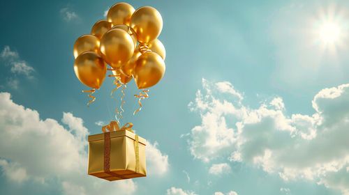 gold gift box airdrop hanging balloons from sky