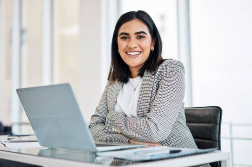 portrait of a young businesswoman working on a laptop in an office - professional woman stock pictures, royalty-free photos & images