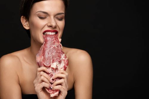 Eating Meat. Beautiful Woman Biting Raw Beef Steak Meat Eating Meat. Hungry Woman With Red Lips Ripping Raw Meat With Teeth. Portrait Of Healthy Girl With Beautiful Face Makeup Biting Beef Steak Meat With Greed. Food And Nutrition Concept. High Resolution eating meat stock pictures, royalty-free photos & images