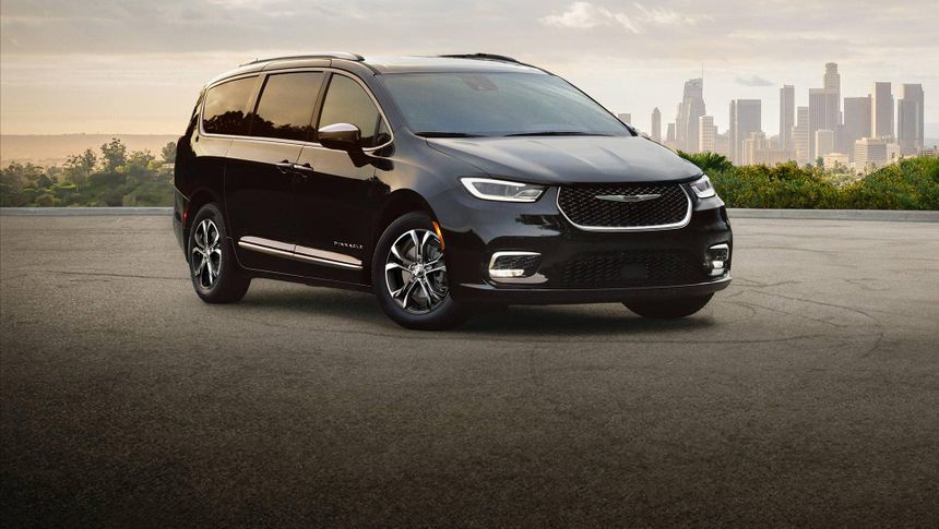 Black Chrysler Pacifica parked with city skyline background showcasing modern family minivan design in Southern California