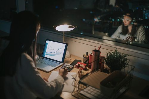 亚洲华裔女白领在办公室工作到深夜独自赶财务报告图片下载