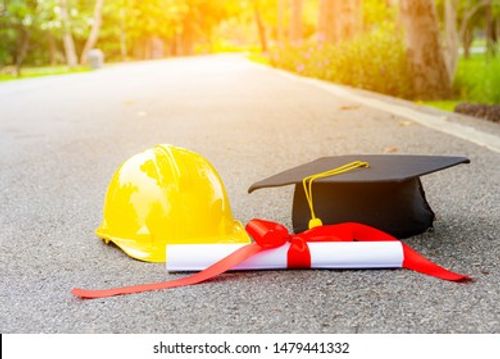 Certificate of graduation cap and helmet for engineers working on the road with green trees in the background Stock Photo