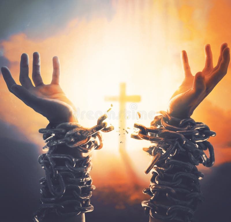 Two hands with broken chains and cross in the background