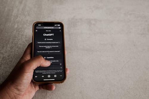 Free Close-up of a hand interacting with ChatGPT on a smartphone, showcasing modern AI technology. Stock Photo