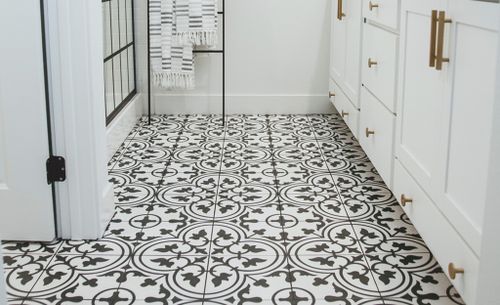 Black and white floor tile in a floral pattern.