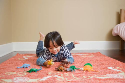 mixed race boy playing with toy dinosaurs - dinosaur names stock pictures, royalty-free photos & images