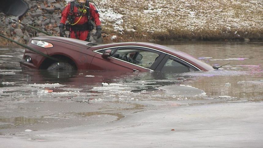 Image for gallery: Driver rescued after car goes into Webster pond