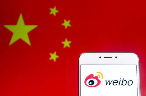 In this photo illustration a Chinese social media platform Weibo logo is seen on an Android mobile device with People's Republic of China flag in the...