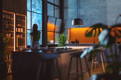 young woman looking through kitchen window on a rainy night - night kitchen stock pictures, royalty-free photos & images