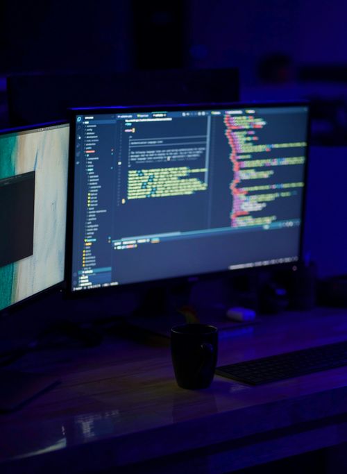 two computer monitors sitting next to each other on a desk