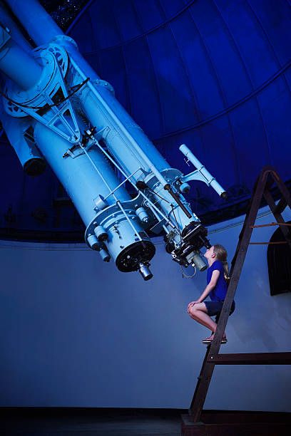 girl looking through a large telescope - large telescope stock pictures, royalty-free photos & images