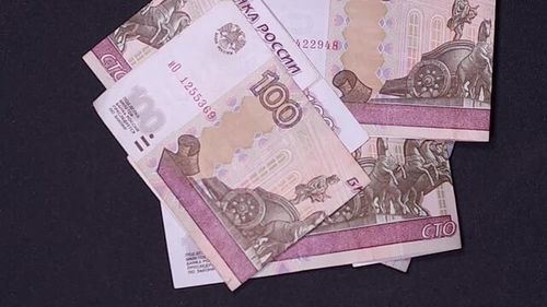 Folded Russian ruble banknotes falling on a black background