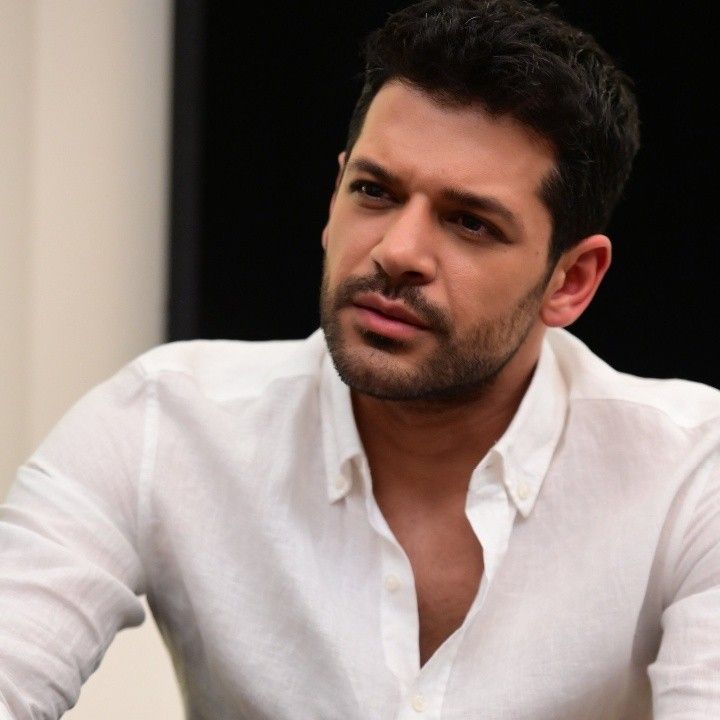 a man in white shirt sitting down with his hands on his hips and looking at the camera