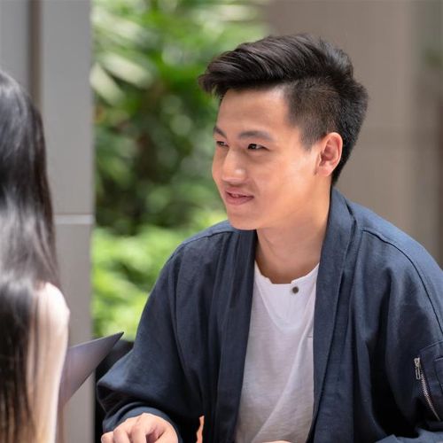 男學生手裡拿著書和筆微笑