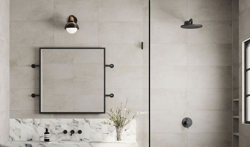 Minimalist shower with large format beige tiles, marble backsplash, and chic black fixtures