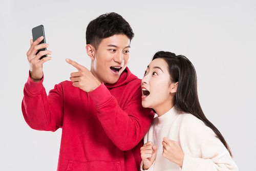 快乐的情侣使用智能手机图片下载