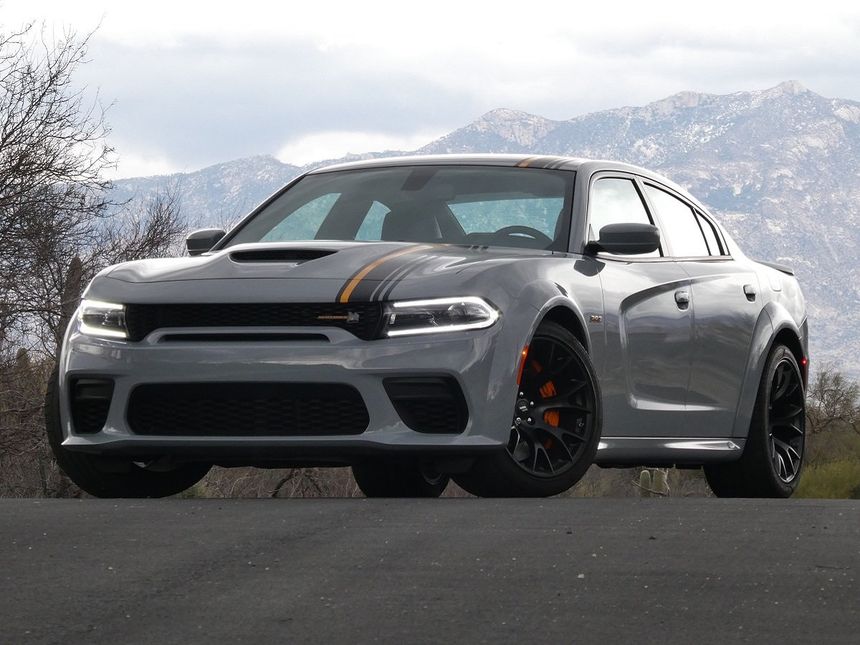 Dodge Charger SRT parked on a road with mountains in the background, showcasing aggressive muscle car styling