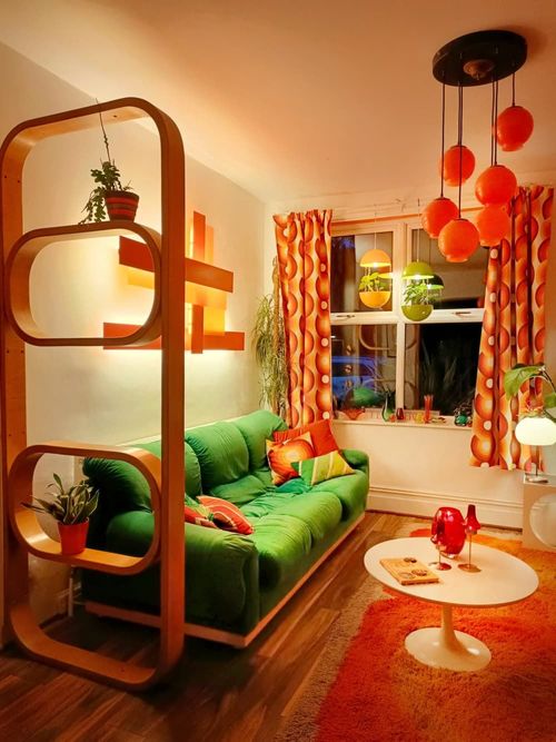a living room with green couches and orange curtains