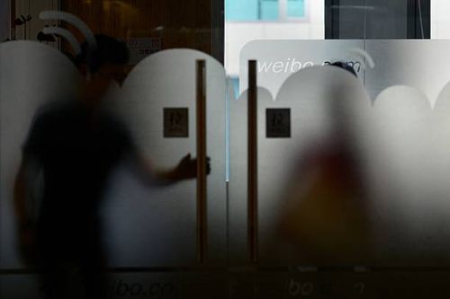 Man walks out of an office of Sina Weibo, widely known as China's version of Twitter, in Beijing on April 16. Sina Weibo is set to go public in the...