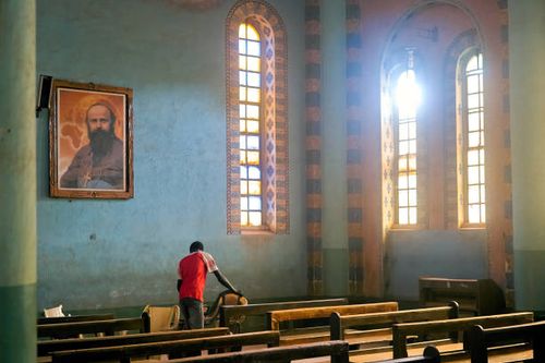 Devotee moves chairs as he prepare for prayers outside the Cathedral of St Mary in Wau, South Sudan on February 12, 2020. - The cathedral was built...
