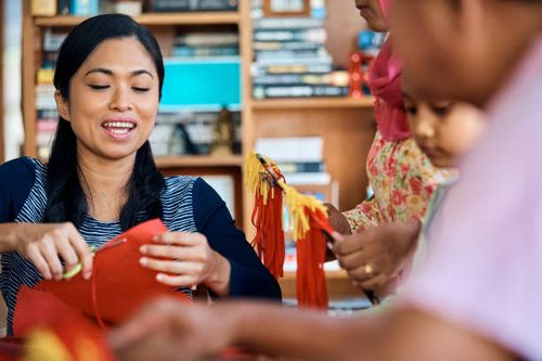 woman making wau bulan with family at home - malaysia wau stock pictures, royalty-free photos & images