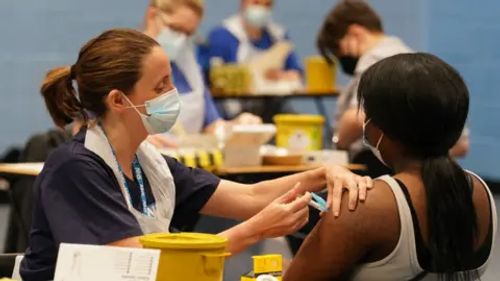 A nurse administers a vaccine to a student.