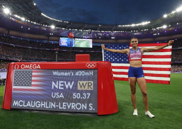 Sydney McLaughlin-Levrone of Team United States poses in front of the scoreboard after winning the gold medal and breaking the World record on day...
