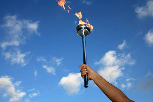 glory of holding flaming torch silhouetted hand holding burning flaming torch over cloudy sky. torch stock pictures, royalty-free photos & images